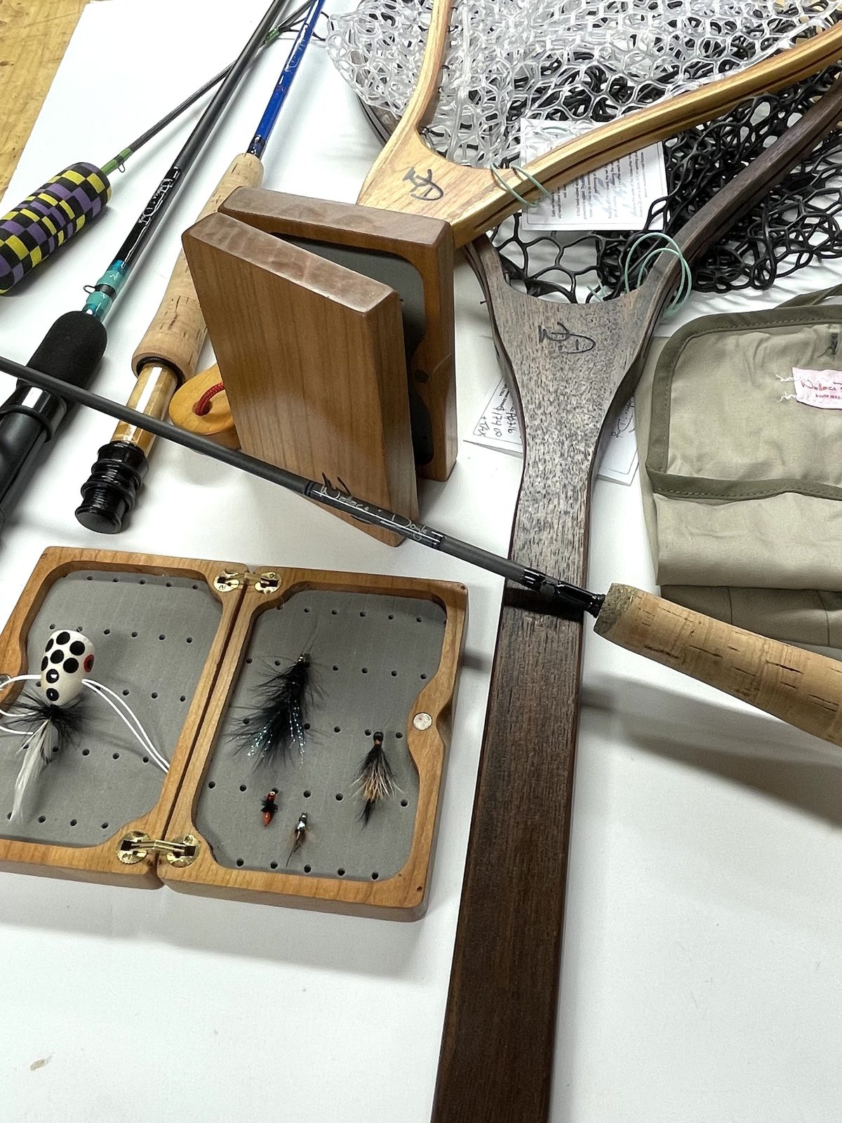 Custom Wallace & Doyle rods, wooden fly boxes, and hardwood landing nets laid out in the workshop